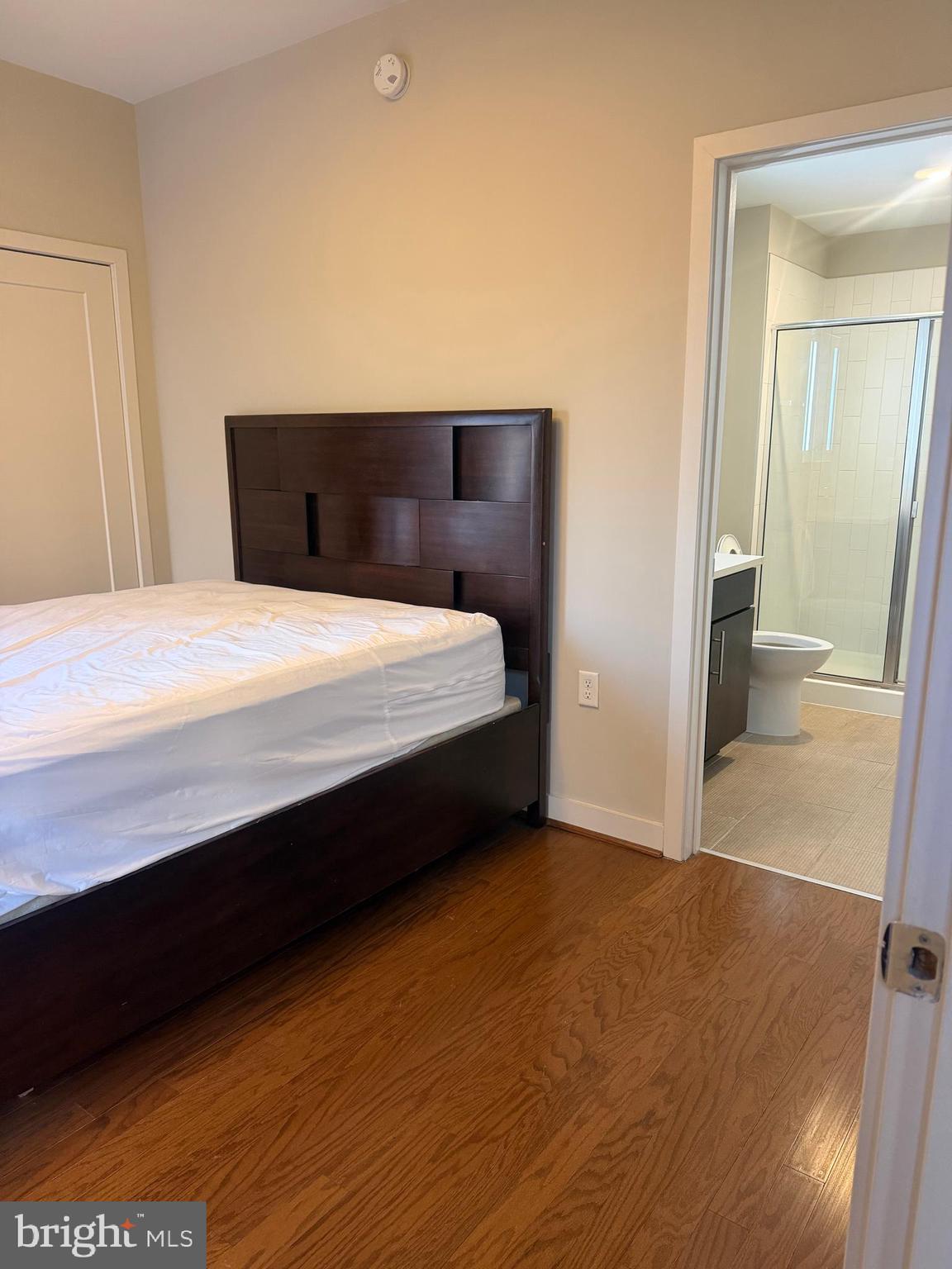 1320 Fenwick Lane, Unit 700 Silver Spring, MD 20910 - Photo 24 of 25 a bedroom with a bed and wooden floor