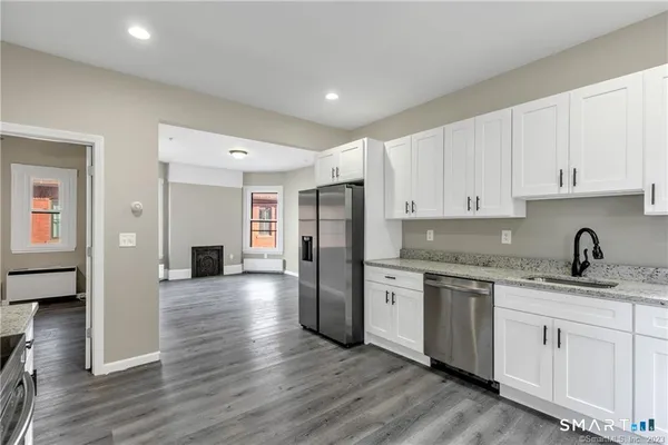a kitchen with stainless steel appliances granite countertop a refrigerator sink and cabinets