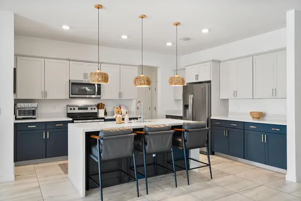 a kitchen with stainless steel appliances kitchen island granite countertop a sink a stove a oven a dining table and chairs