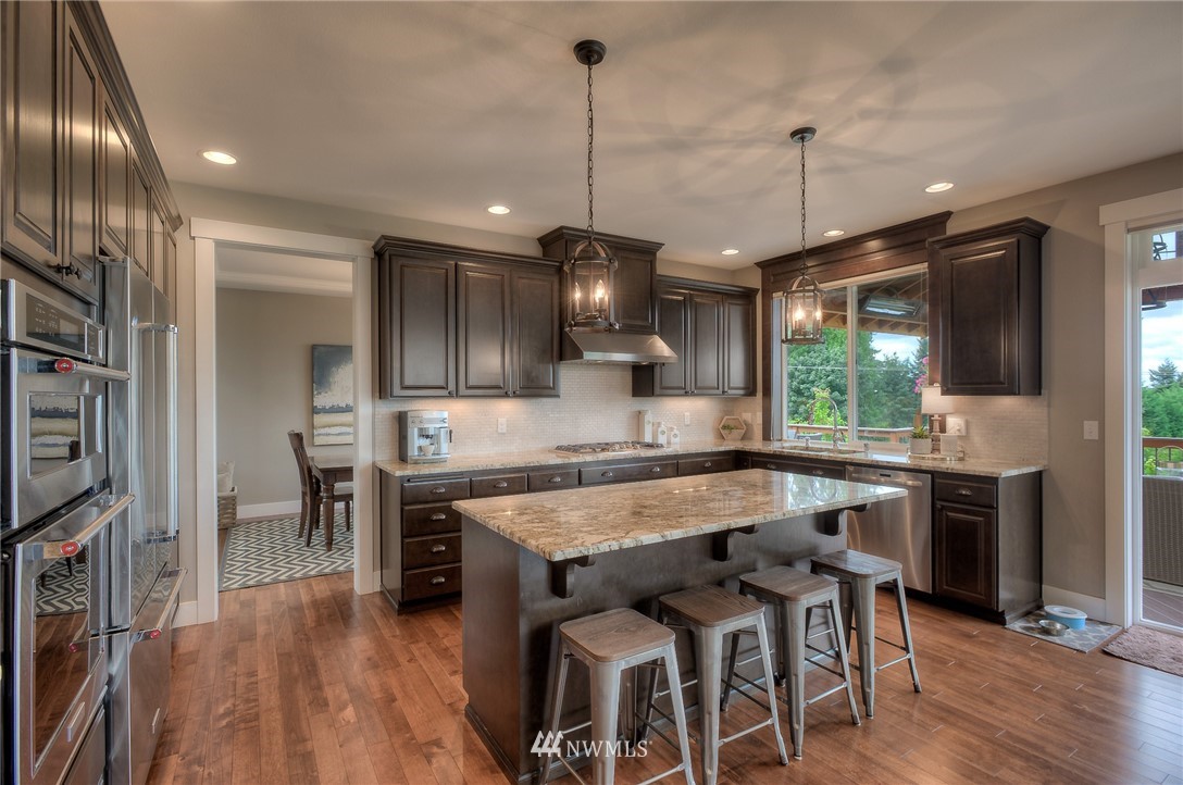 22008 43rd Drive Southeast Bothell, WA 98021 - Photo 5 of 25 a kitchen with stainless steel appliances granite countertop a stove refrigerator and a wooden floor