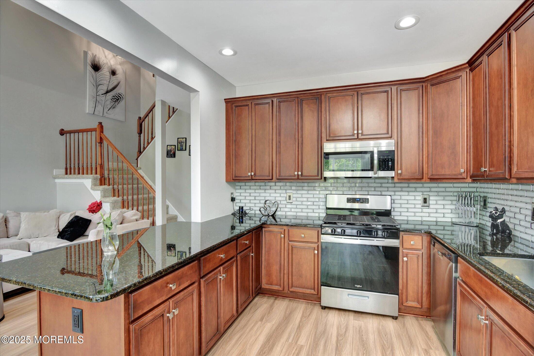 45 Brookfield Drive Jackson, NJ 08527 - Photo 18 of 39 a kitchen with stainless steel appliances granite countertop a stove a sink dishwasher and a microwave oven with wooden floor
