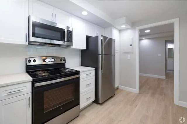 a kitchen with stainless steel appliances a stove microwave and refrigerator