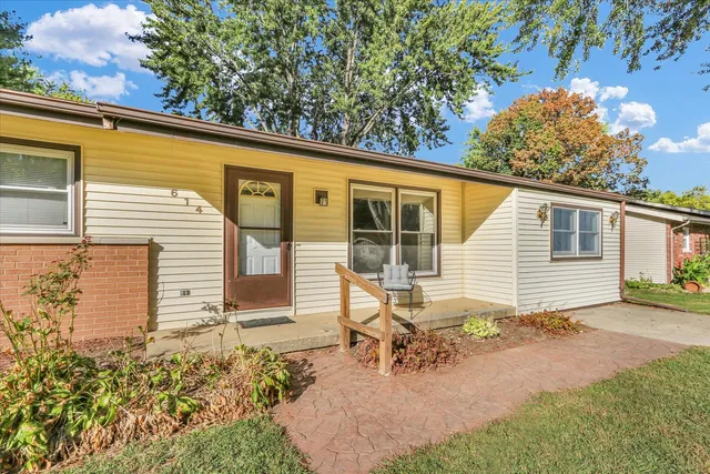 a view of a house with backyard and sitting area