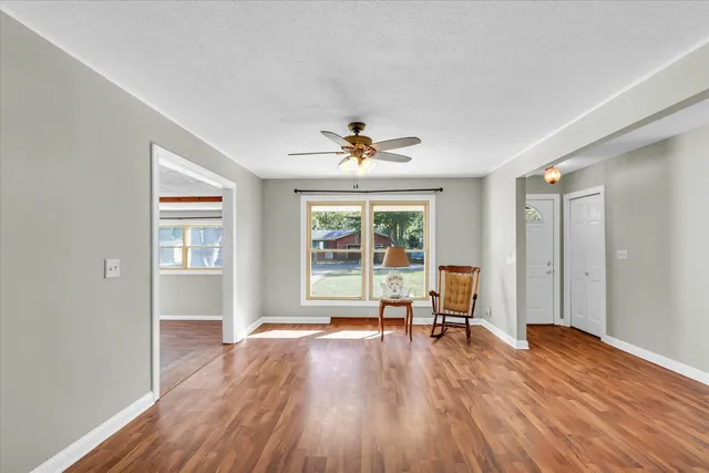 a view of a livingroom with wooden floor and a ceiling fan
