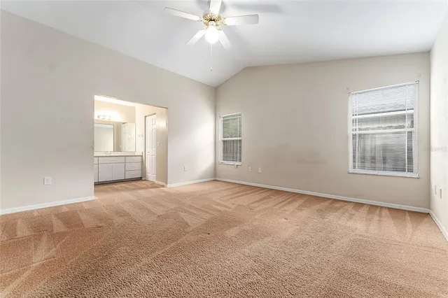 an empty room with fan and windows