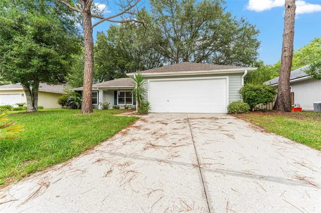 a front view of a house with a yard and trees