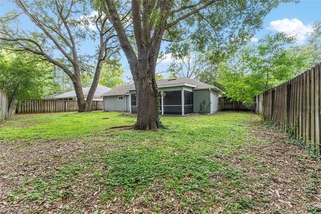 a view of a yard with wooden fence and trees
