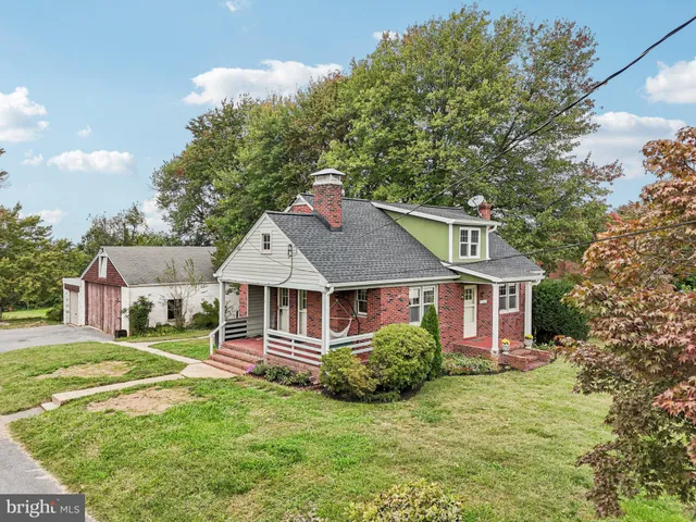 a front view of a house with a garden and trees