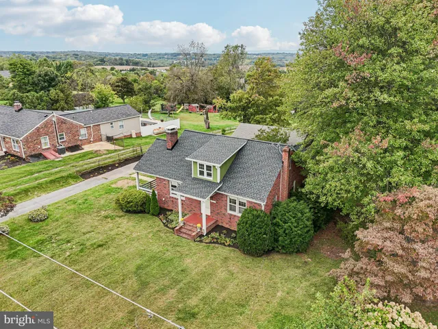 an aerial view of a house with garden space and street view