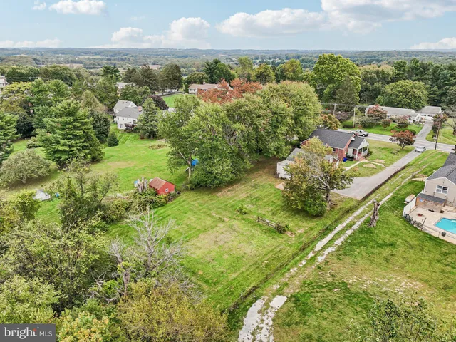 an aerial view of residential houses with outdoor space and trees