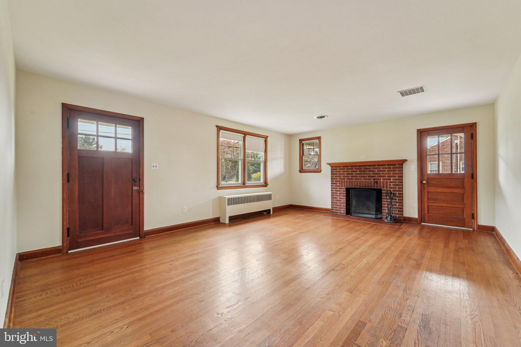 1008 North Main Street Mount Airy, MD 21771 - Photo 6 of 52 an empty room with wooden floor fireplace and windows