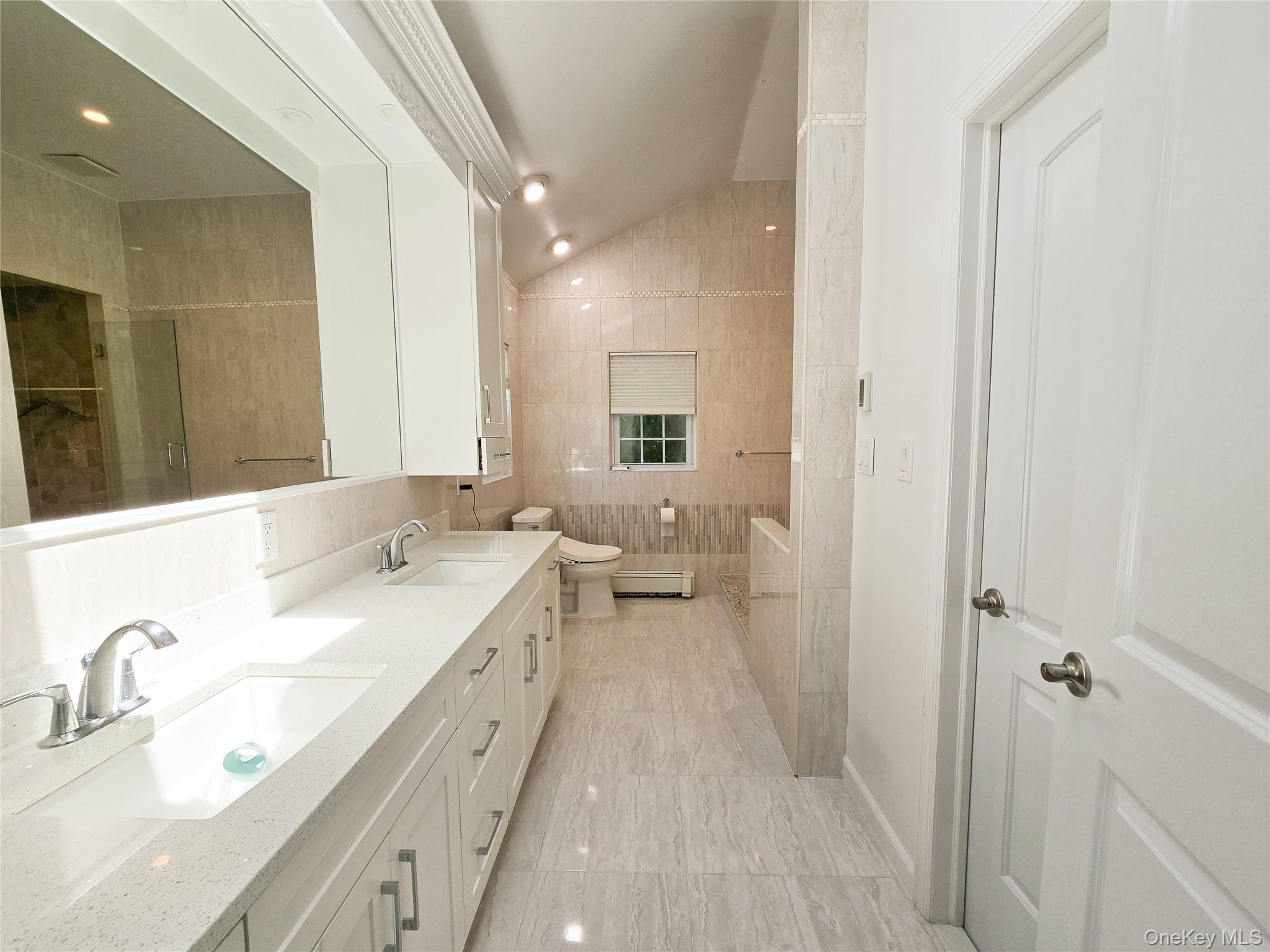 249 Cold Spring Road Syosset, NY 11791 - Photo 16 of 28 a spacious bathroom with a double vanity sink and mirror