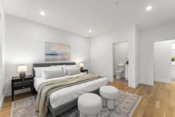 a bedroom with a bed and wooden floor