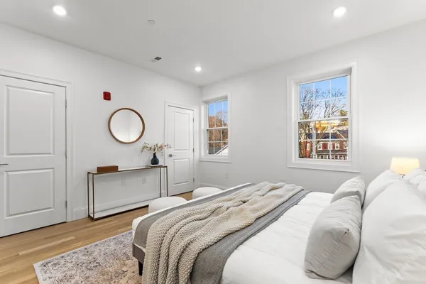 a bedroom with a bed and wooden floor