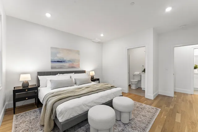 a bedroom with a bed and wooden floor