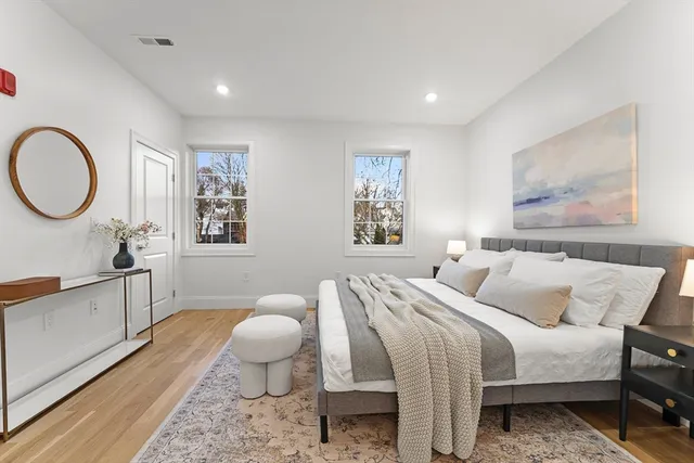 a bed room with a bed and painting on the wall