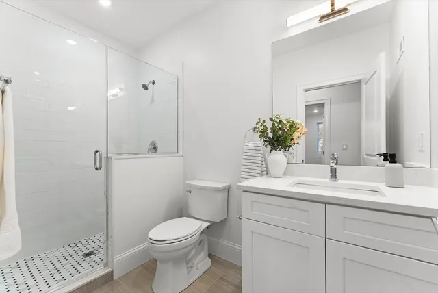 a bathroom with a sink a toilet and shower