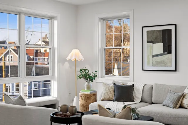 a living room with furniture fireplace and a window