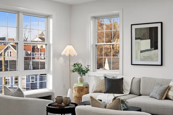 a living room with furniture fireplace and a window