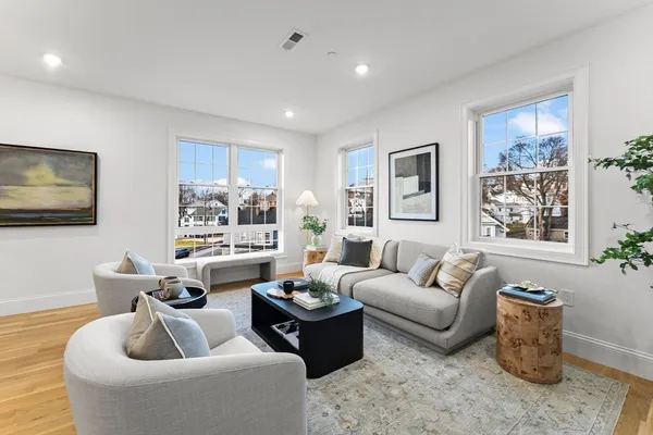 a living room with furniture a rug and a flat screen tv