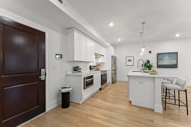 a kitchen with white cabinets and stainless steel appliances