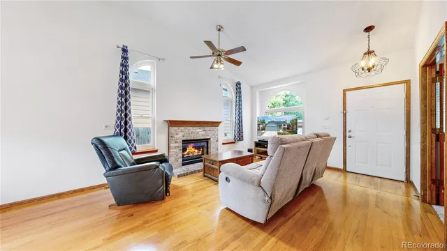 a living room with furniture a fireplace and a potted plant