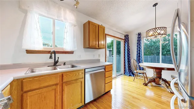 a kitchen with a sink a table chairs and a wooden floor