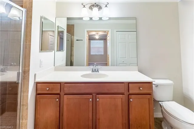 a bathroom with a sink vanity mirror and toilet