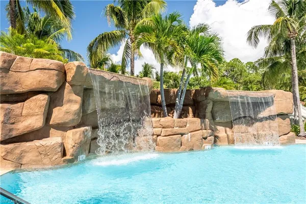 a view of a house with a yard and palm trees