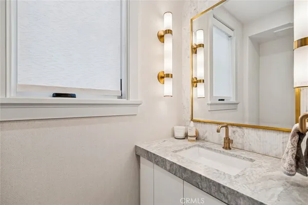 a bathroom with a granite countertop sink and a mirror