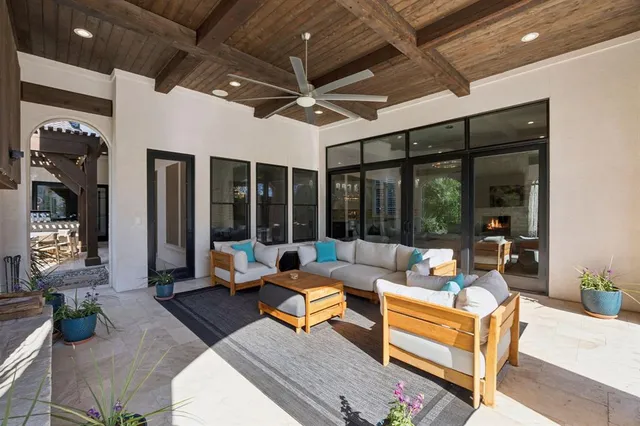 a living room with patio furniture and a large window