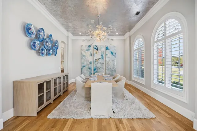 a view of a dining room with furniture a chandelier and wooden floor