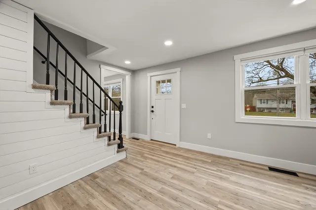 a view of a hallway with wooden floor and stairs