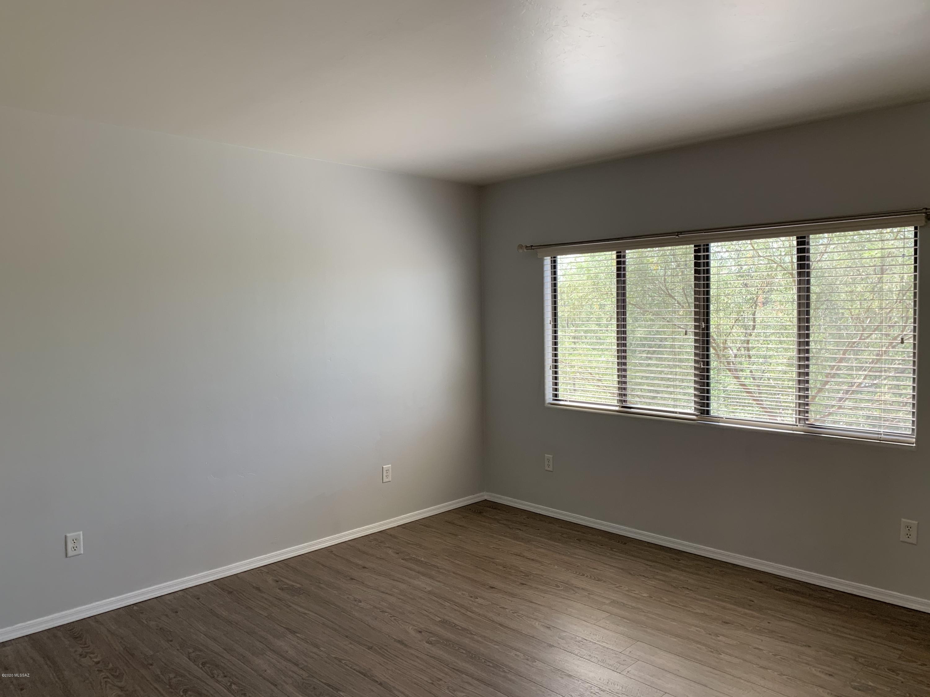 4181 North Fortune Loop Tucson, AZ 85719 - Photo 20 of 39 an empty room with wooden floor and windows