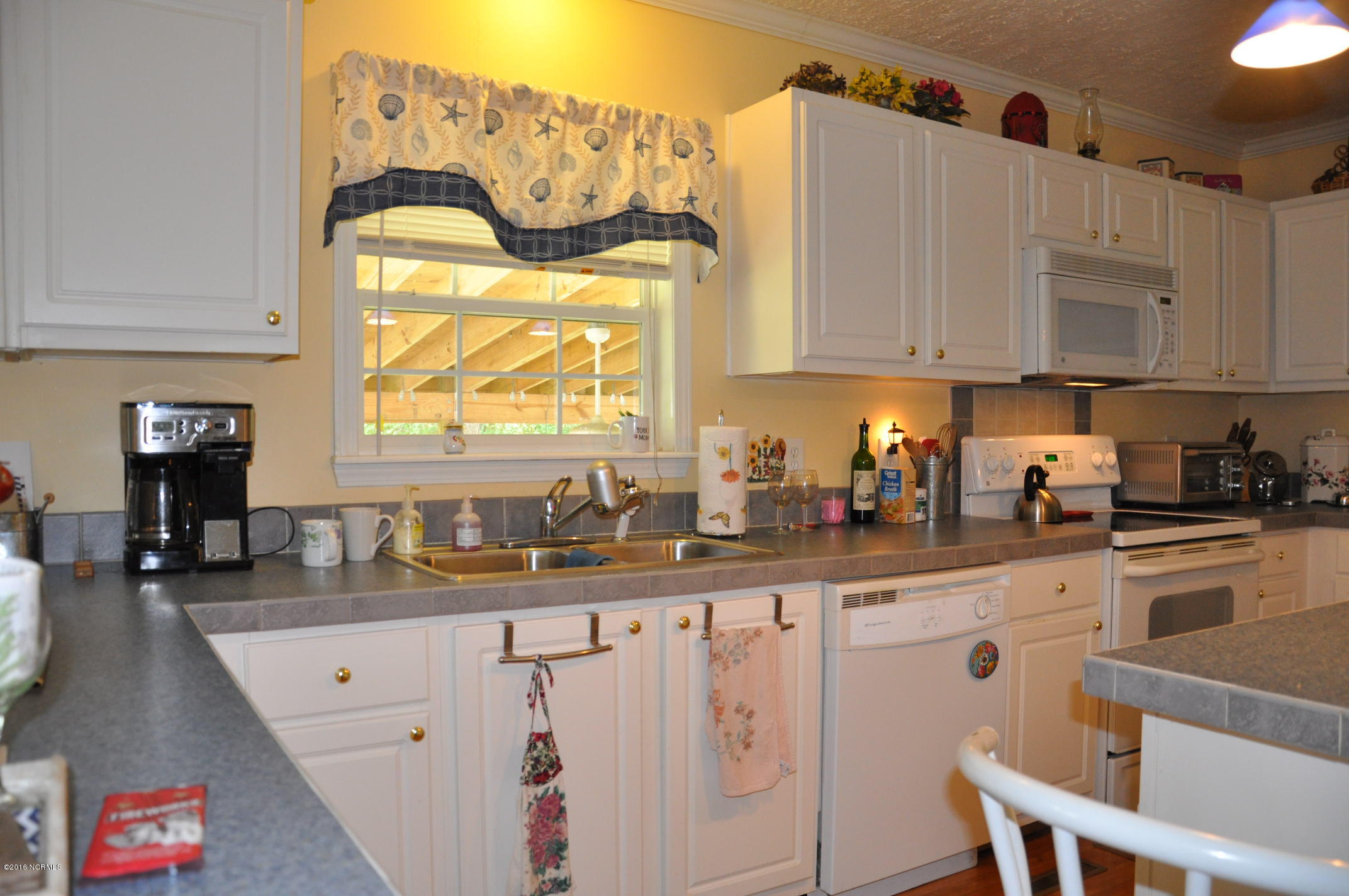 6882 Maple Road Northwest Ash, NC 28420 - Photo 9 of 35 Plenty of counter top space and cabinets for all of your kitchen wares.