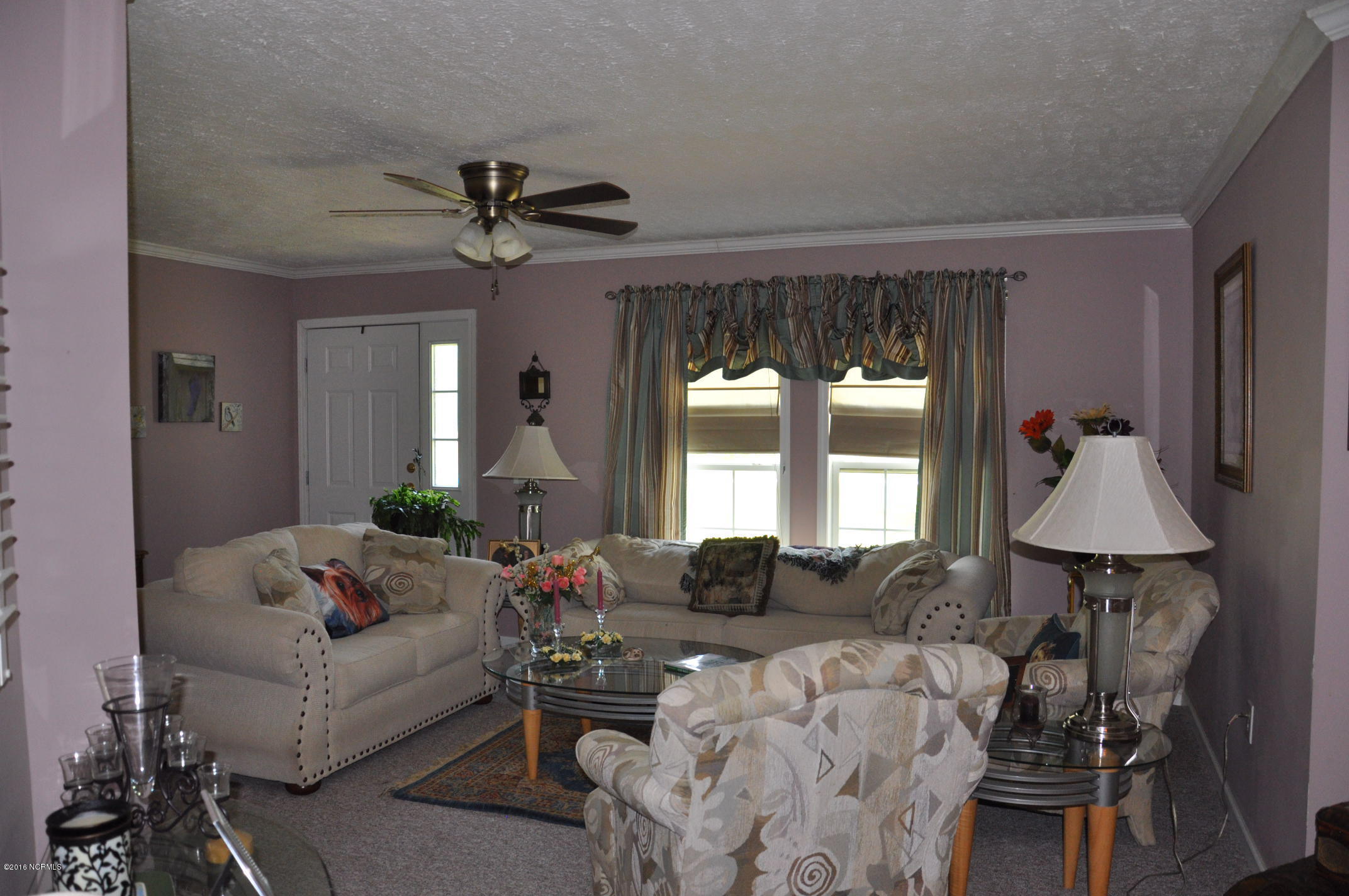 6882 Maple Road Northwest Ash, NC 28420 - Photo 13 of 35 Formal living room area with a bedroom to the left and a bedroom to the right.