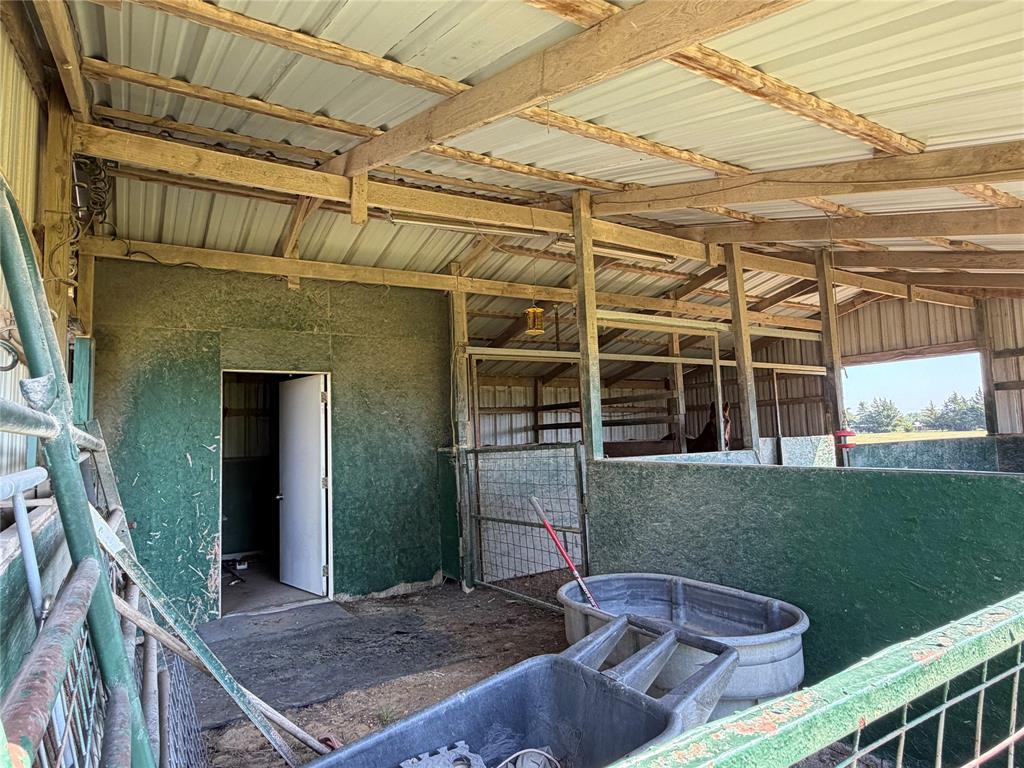330 South Goode Road Wilmer, TX 75172 - Photo 35 of 37 Barn structure featuring exposed wood beams, corrugated metal roofing, and green-paneled interior walls