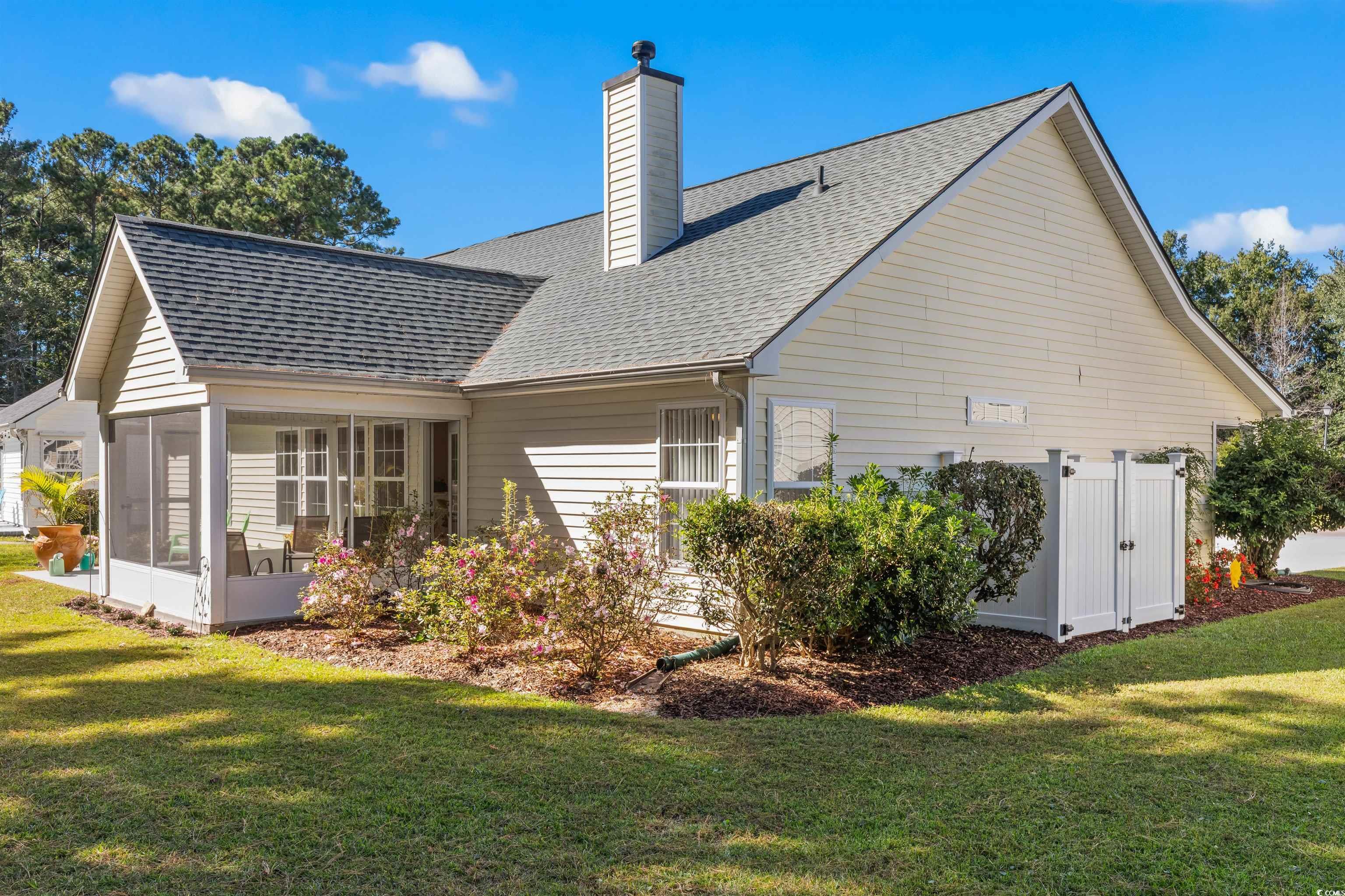 3505 Arrowhead Boulevard Myrtle Beach, SC 29579 - Photo 36 of 40 Rear view of house featuring a sunroom, roof with shingles, and a lawn