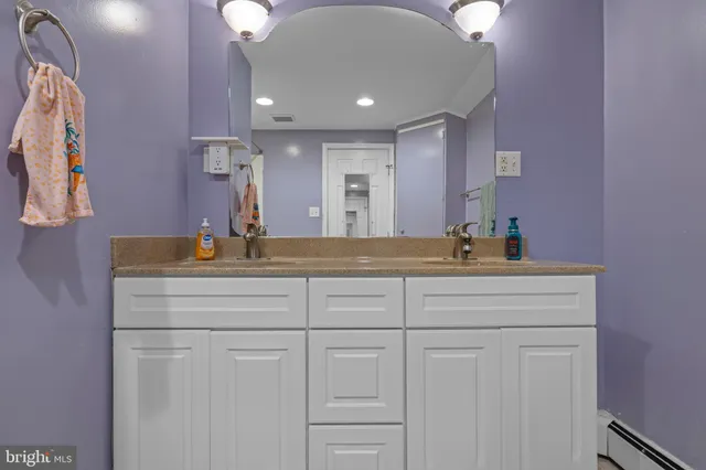 a bathroom with a sink vanity and mirror