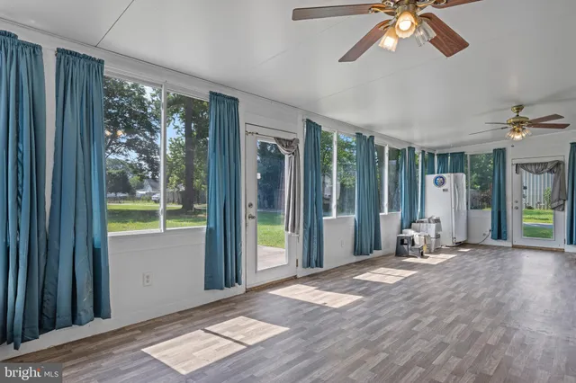 a view of a livingroom with wooden floor and furniture