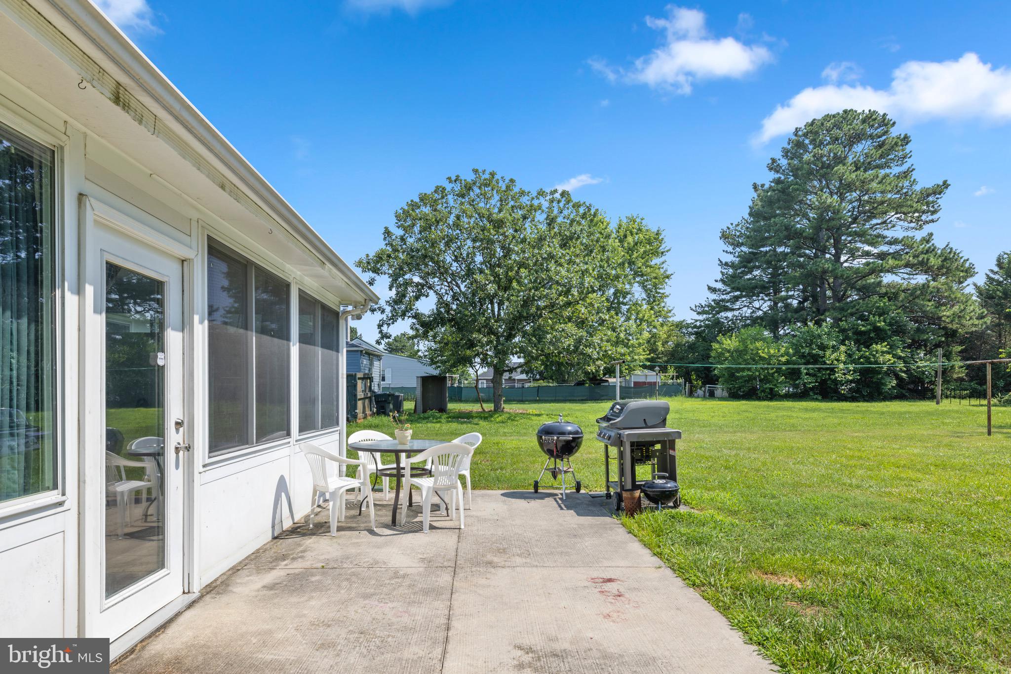 102 Roe Street Greensboro, MD 21639 - Photo 35 of 42 a view of a chair and tables in the patio with a backyard