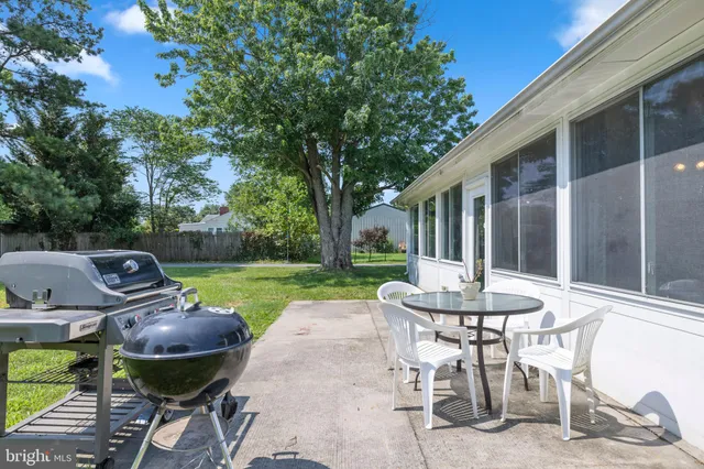 a view of a patio with table and chairs and a barbeque