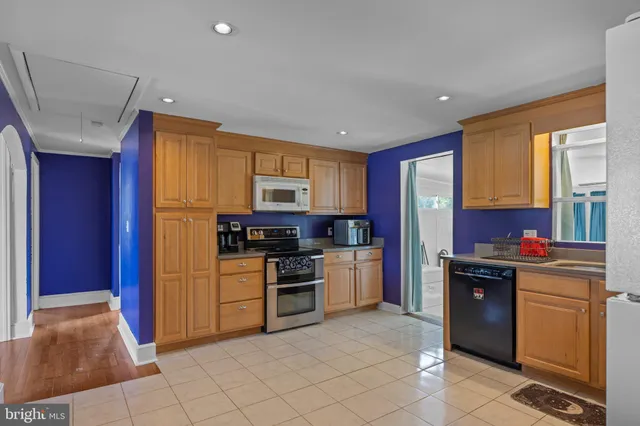 a kitchen with granite countertop a refrigerator and a stove top oven