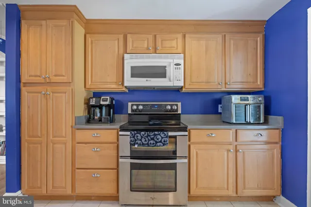 a kitchen with white cabinets and appliances