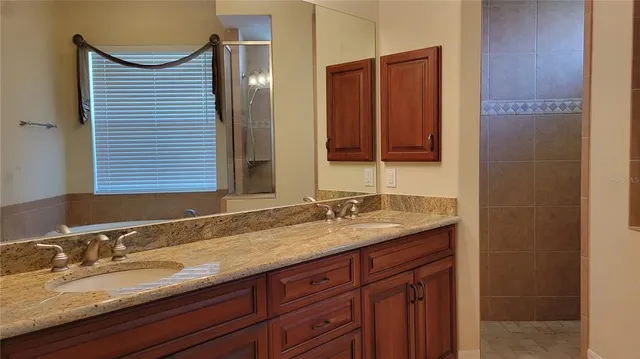 a bathroom with a granite countertop sink and a mirror