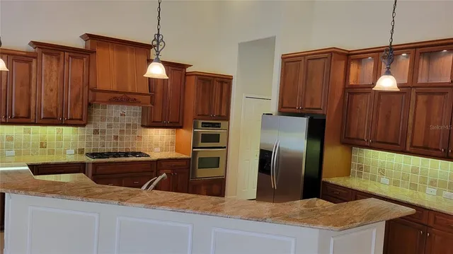 a kitchen with granite countertop a refrigerator and a sink