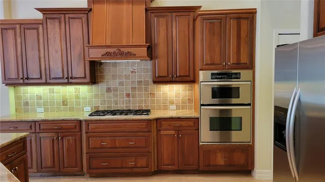 a kitchen with granite countertop wooden cabinets and stainless steel appliances