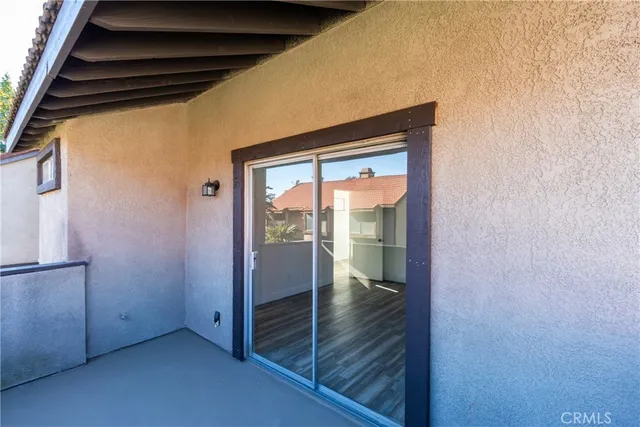 a view of a living room with a large window and wooden floor