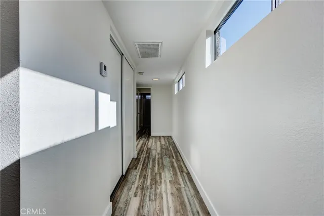 a view of a living room with a sink a potted plant and a wooden floor