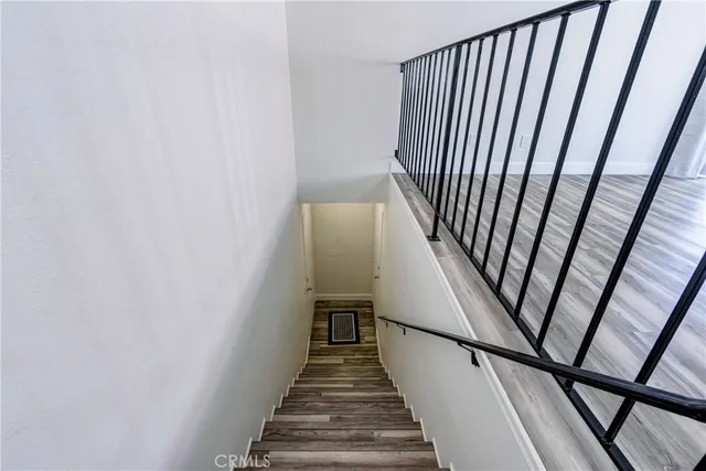 an empty room with wooden floor fireplace and windows